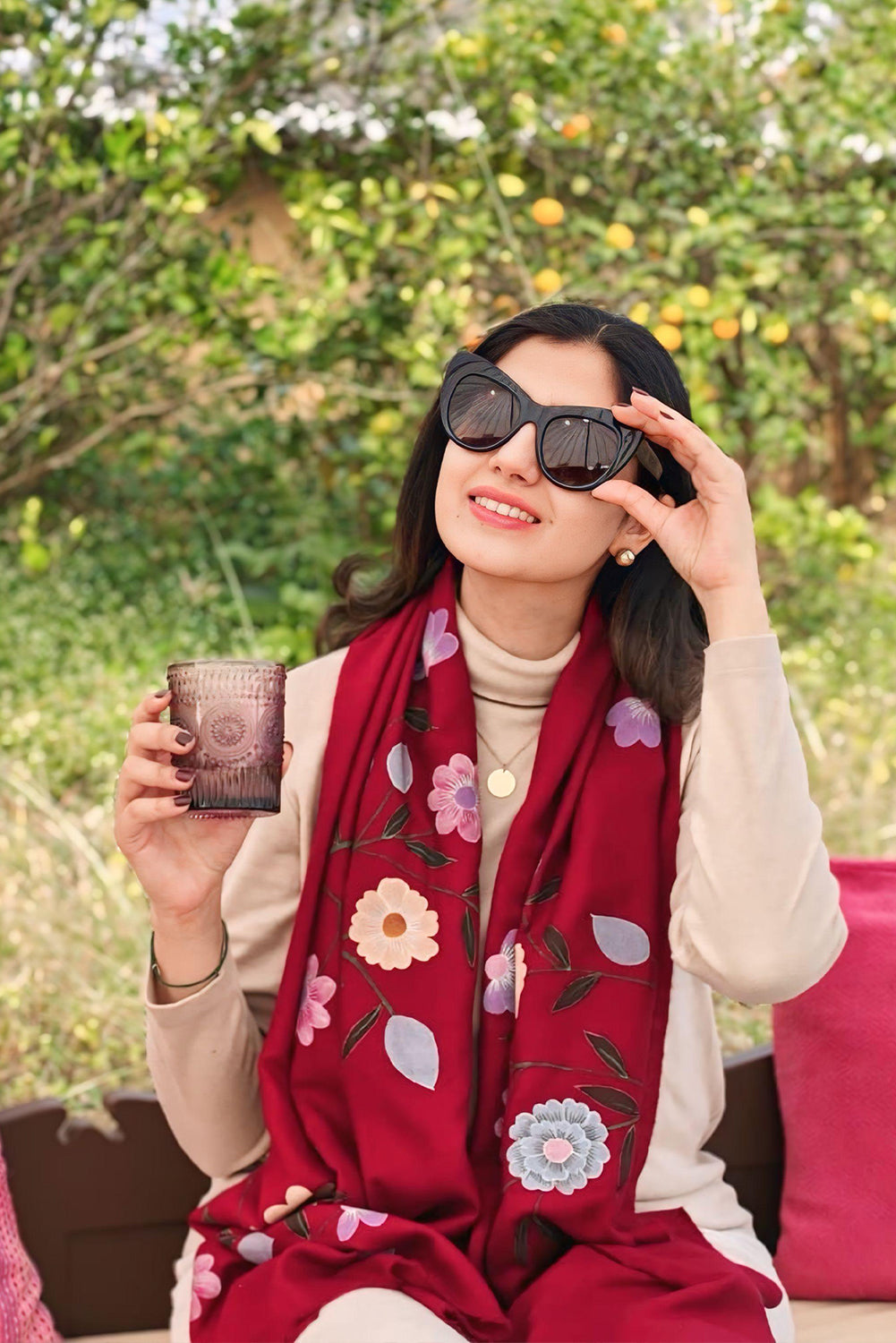 Woman wearing a red floral scarf, holding sunglasses and a mug outdoors.

Hand-painted. 
Designer label
Baavli luxury designer store, New Delhi.
Indian wedding, lehenge, Bride, Indian bride, bridesmaid, Suit sets, Kaftan, sharara, jacket, kurta.
baavli launching its new collection, Hand painted, hand embroidered, Designer Label
Winter 
Pashmina