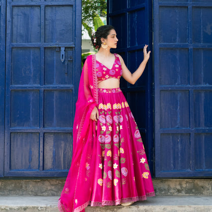 Woman in a bright pink traditional outfit with floral patterns standing in front of a blue door.

Baavli luxury designer store, New Delhi.
Indian wedding, lehenge, Bride, Indian bride, bridesmaid, Suit sets, Kaftan, sharara, jacket, kurta.
baavli launching its new collection, Dhan Mill, Hand painted, hand embroidered, Designer Label
